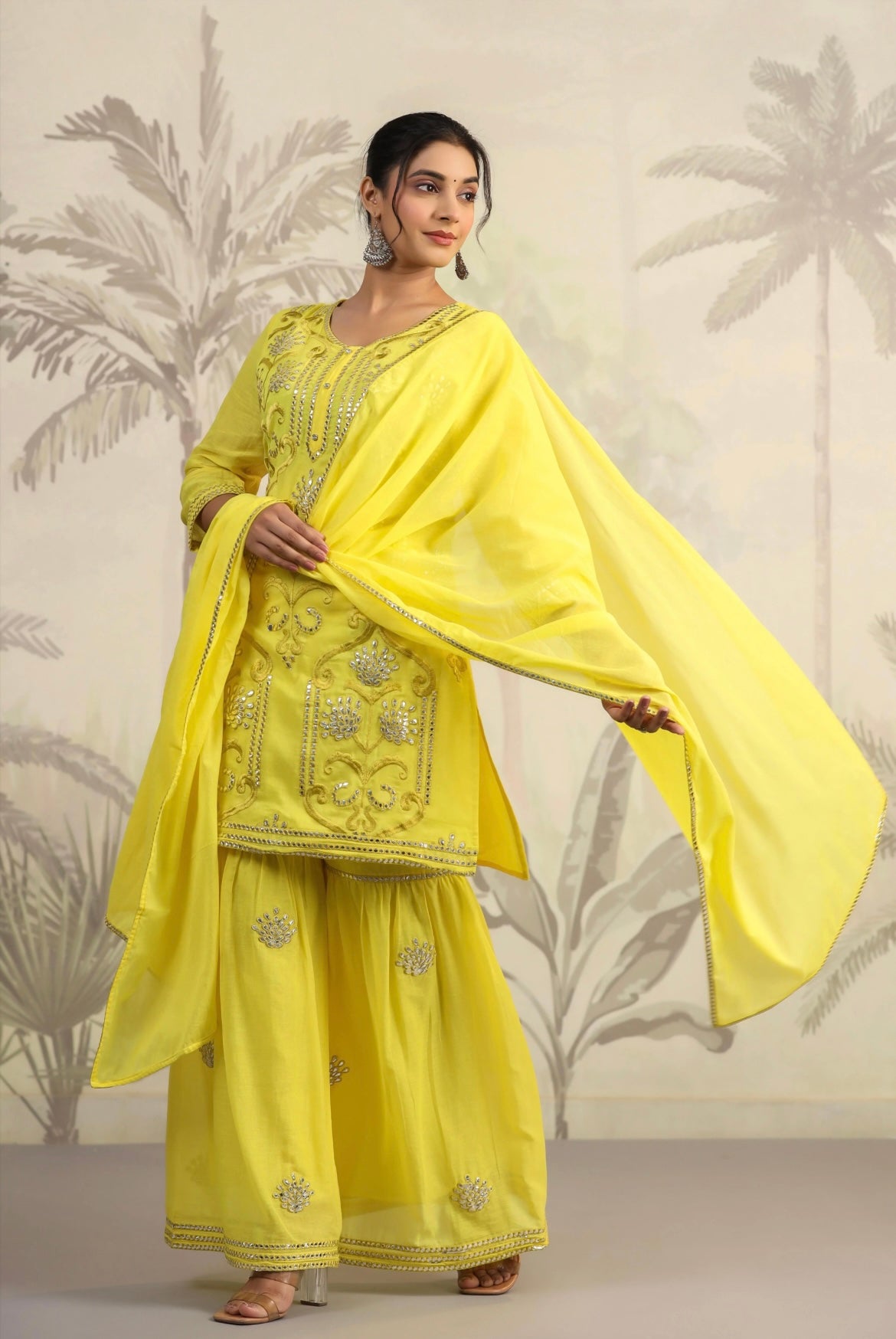 Cotton women’s pant suit in mulmul. Sharara suit with full embroidery in yellow colour. Left view.