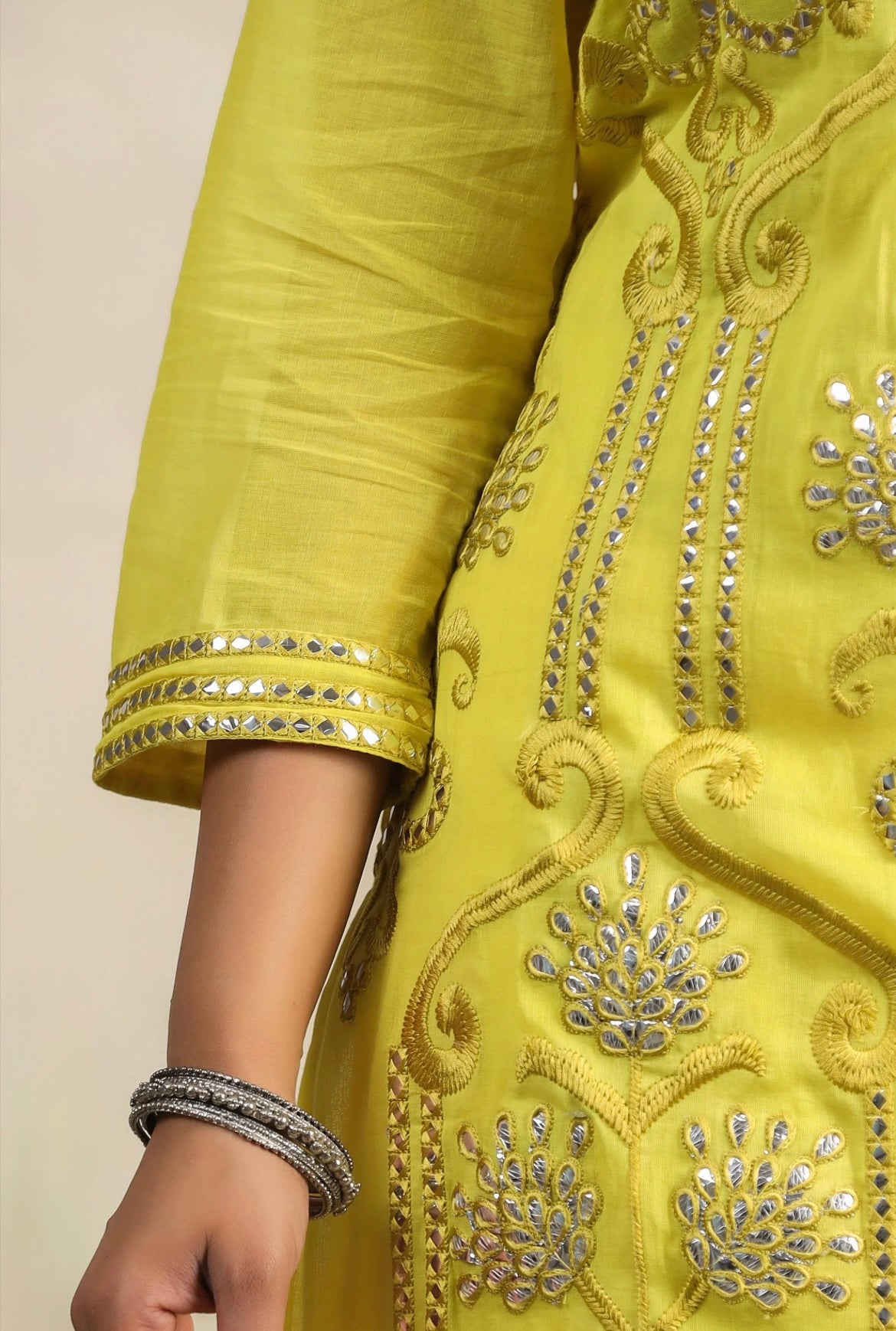 Cotton women’s pant suit in mulmul. Sharara suit with full embroidery in yellow colour. Detail view.