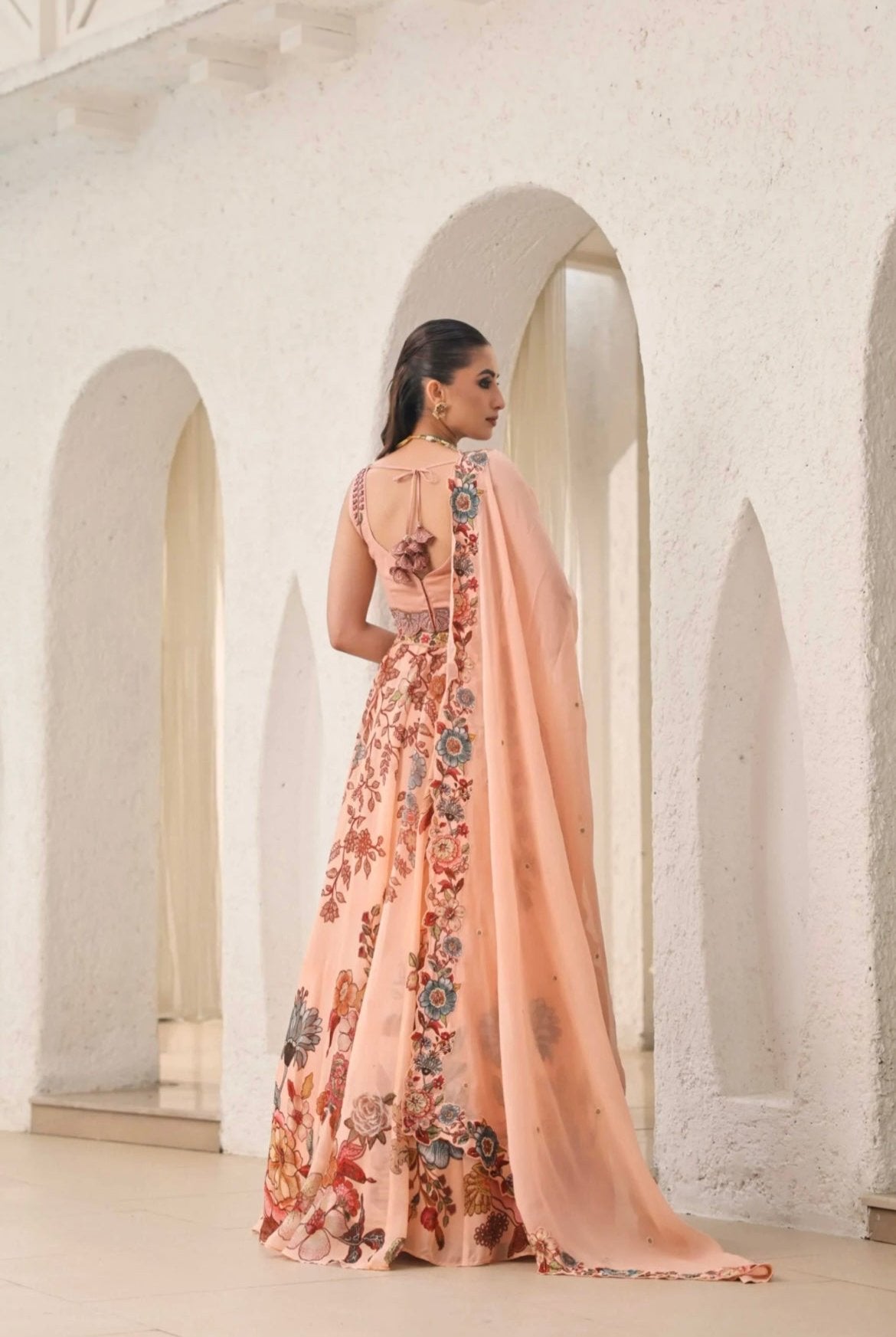 Lehenga choli for women. Peach colour made in Organza fabric with hand embroidery and print. Back View.