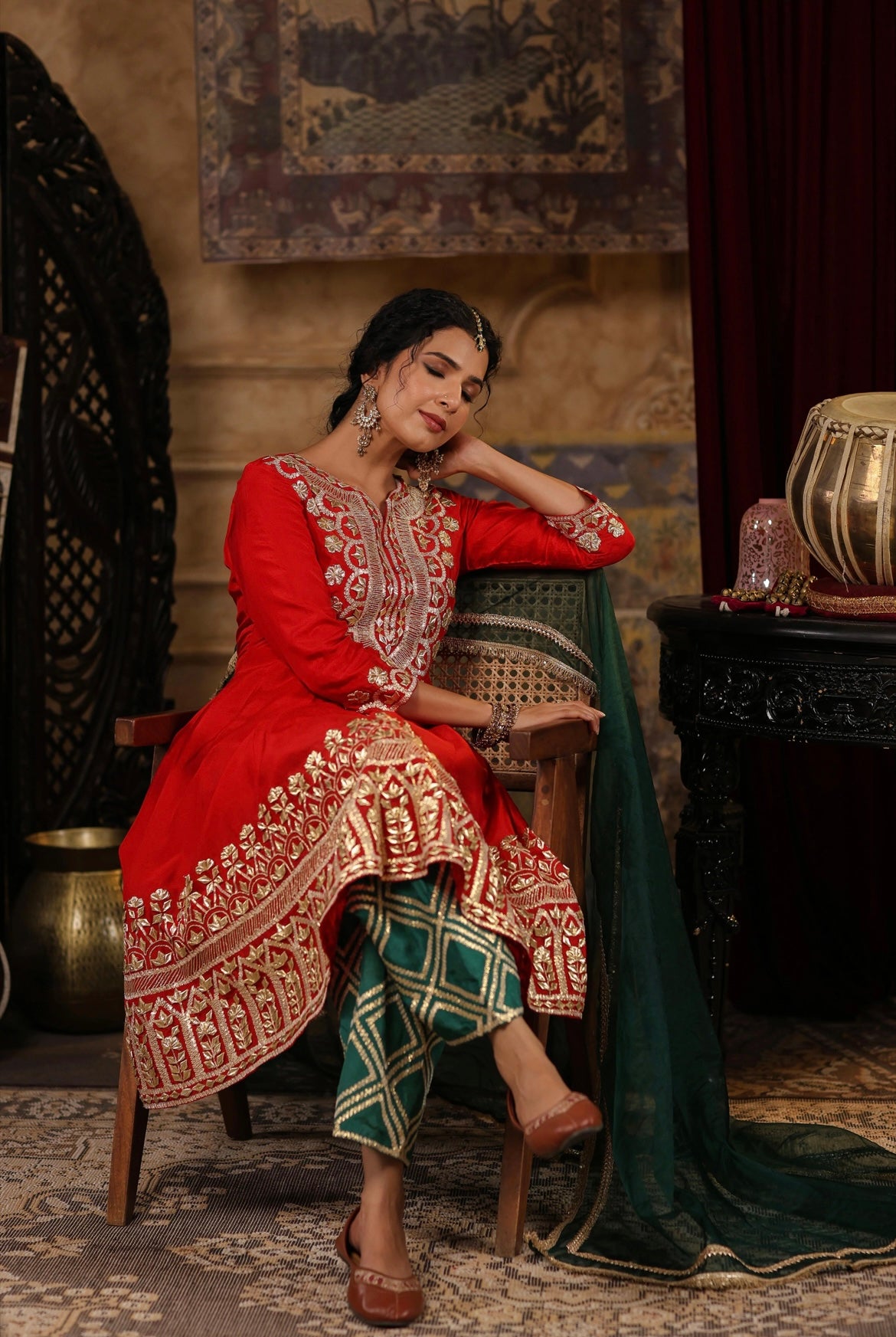 Red and Dark Green Silk Anarkali Salwar Set with Gota embroidery. Sitting view.